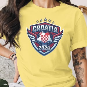 Croatia 2026 soccer crest with wings and stars on a yellow t-shirt.