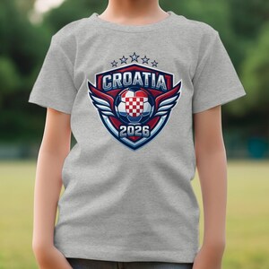 Croatia 2026 soccer logo on grey t-shirt with blurred background.