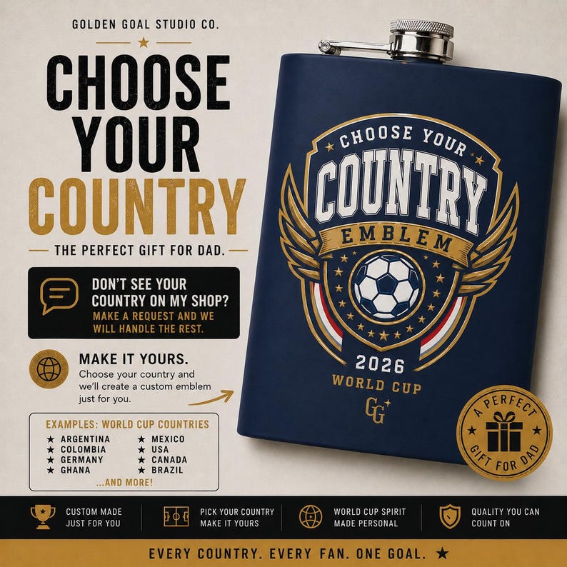 May include: A dark blue metal flask featuring a gold and white graphic of a soccer ball inside a shield emblem with wings, text reading CHOOSE YOUR COUNTRY EMBLEM 2026 WORLD CUP, and a small GG logo. The flask has a silver screw-top cap.