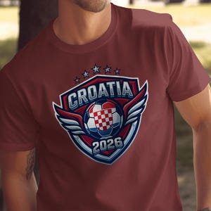 Maroon t-shirt with Croatia 2026 soccer logo featuring wings and shield.