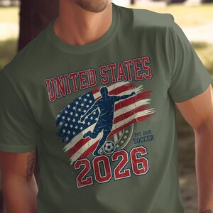Olive t-shirt with distressed USA flag, soccer player, and "United States Soccer Est. 2026".
