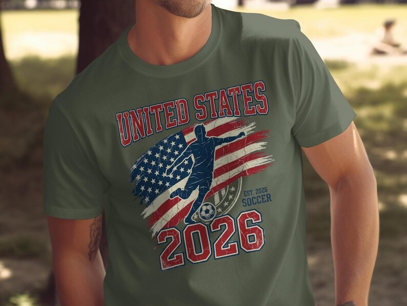 Olive t-shirt with distressed USA flag, soccer player, and "United States Soccer Est. 2026".