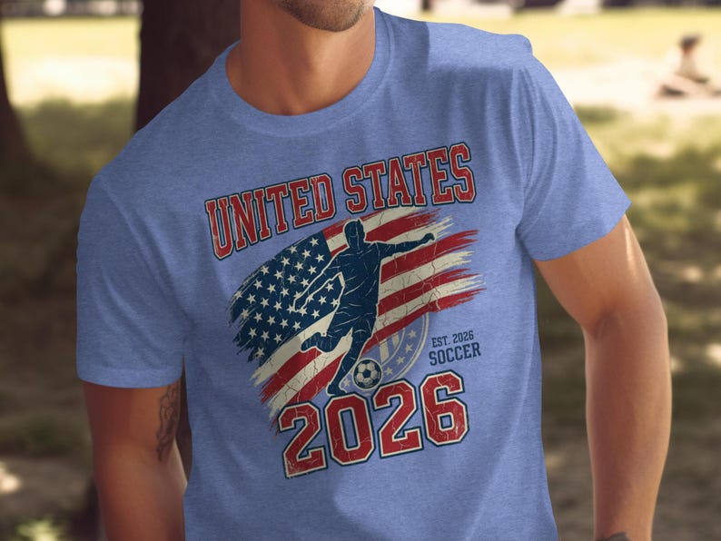 Blue t-shirt with distressed United States flag and soccer player design for 2026.