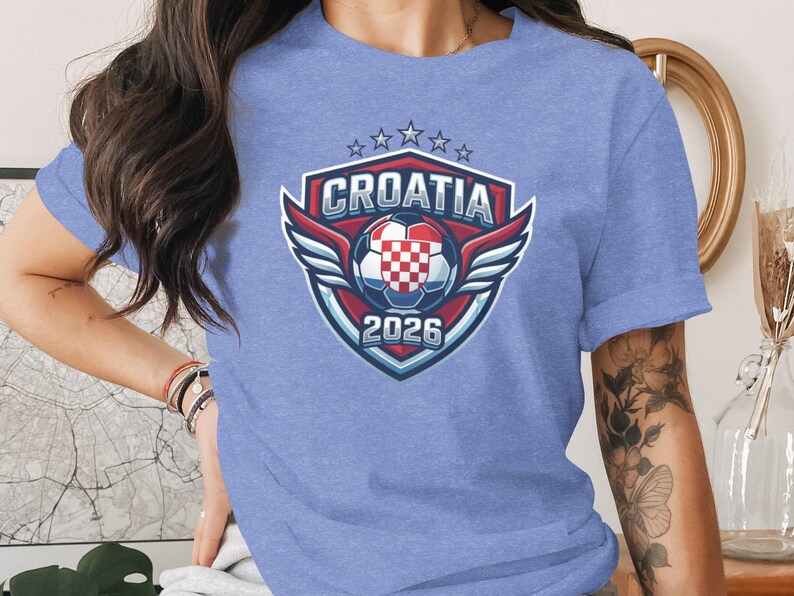 Croatia 2026 crest with wings, soccer ball, and stars on blue t-shirt.