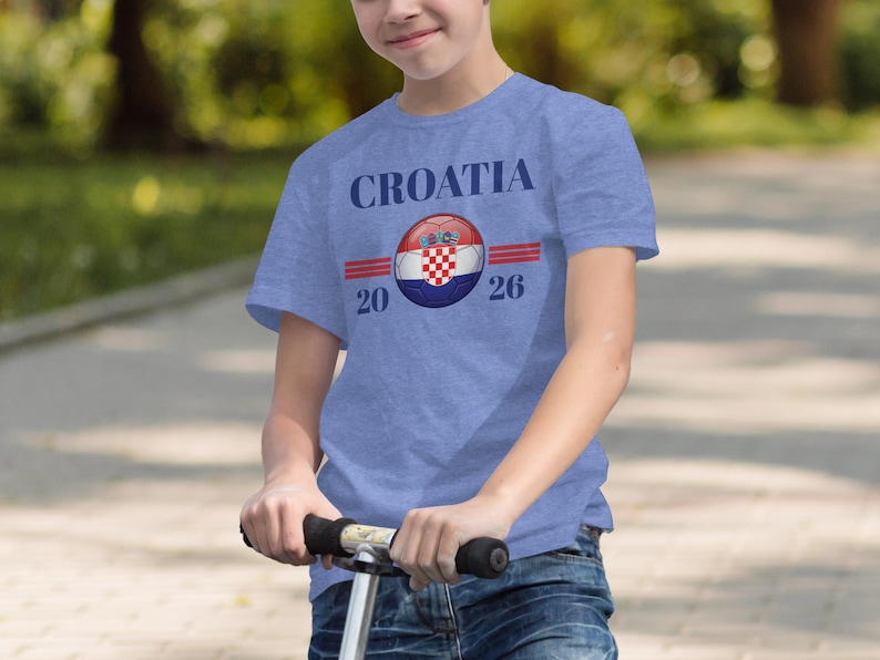 Boy wearing a blue t-shirt with "CROATIA 2026" and Croatian flag design.