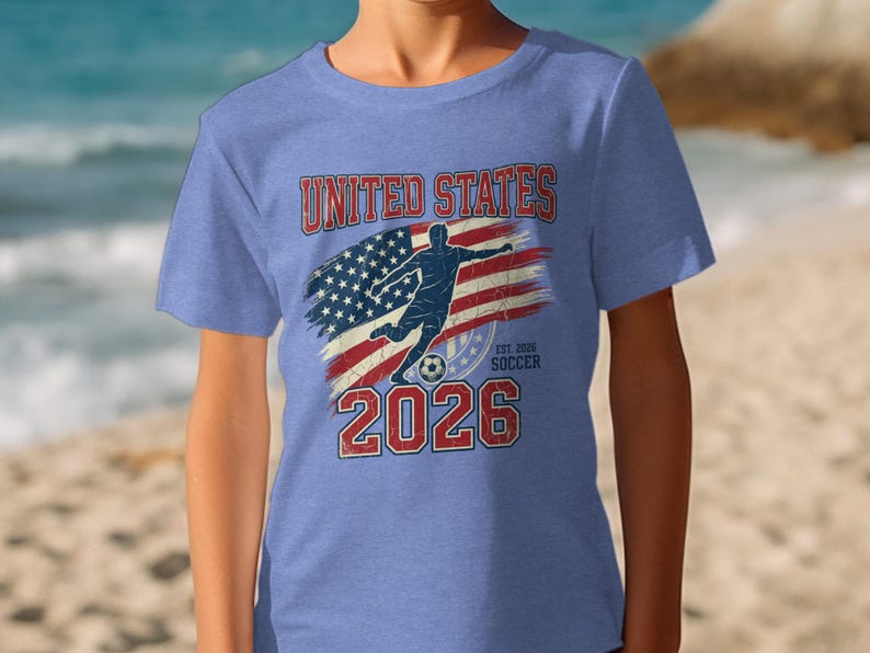 "United States Soccer 2026" text and USA flag graphic on a blue t-shirt.
