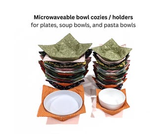 May include: Two stacks of fabric bowl cozies and holders for plates, soup bowls, and pasta bowls. The fabric features various patterns and colors, including green, orange, and dark prints. Two individual cozies hold a white plate and a white bowl.