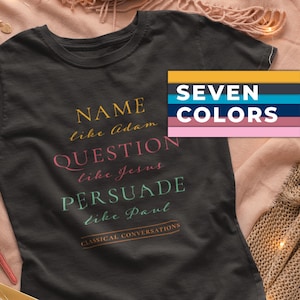 Pode incluir: T-shirt cinzenta escura com as palavras "NAME like Adam, QUESTION like Jesus, PERSUADE like Paul" em várias cores. O texto "CLASSICAL CONVERSATIONS" está em baixo. Uma paleta de cores com o texto "SEVEN COLORS" está no canto.