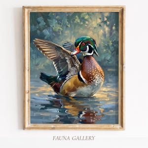 May include: A framed painting depicting a Wood Duck with outstretched wings, displaying vivid colours. The duck features a green and white head, a red beak, and brown and white feathers. The artwork is set in a watery environment with a blurred background of foliage.