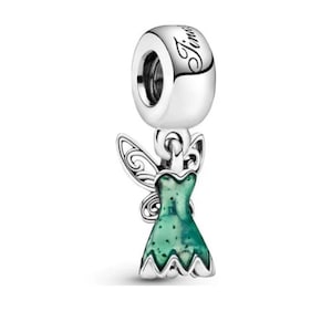 May include: A silver charm with the word "Tims" engraved on the top. The charm features a green dress with a fairy wing design. The charm is designed to be a pendant or bead for a bracelet or necklace.