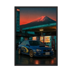 May include: A framed wall art print featuring a blue Subaru rally car parked at a petrol station at dusk. In the background, a snow-capped mountain glows under a sunset sky. A vertical sign with Japanese text stands near illuminated vending machines.