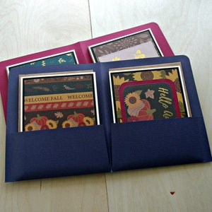 May include: A blue folder containing four cards. The cards feature autumnal designs with sunflowers, pumpkins, and the text "Welcome Fall" and "Hello Autumn".