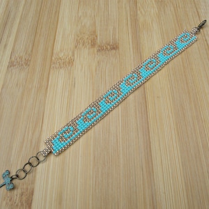 May include: A turquoise and gold beaded bracelet with a dragonfly charm. The bracelet has the word "EVERMORE" spelled out in turquoise beads.