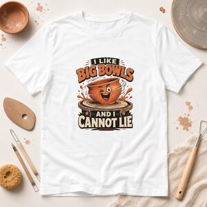 Peut inclure: T-shirt blanc avec un motif « I Like Big Bowls and I Cannot Lie ». Le motif représente un bol de dessin animé qui fait un clin d'œil sur une roue de potier. Des outils de poterie et un bol en céramique entourent le t-shirt.