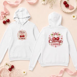 Puede incluir: Sudadera con capucha blanca con un diseño de cereza en la parte delantera y trasera. La parte delantera presenta un gráfico de cereza con el texto "Cherry Coded" en un marco decorativo. La parte trasera tiene un diseño similar con un lazo y detalles florales.