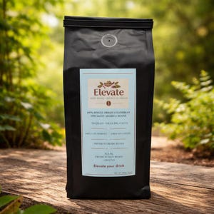 Könnte beinhalten: Ein schwarzer Kaffeebeutel der Marke Elevate mit einem hellblauen Etikett. Das Etikett lautet "100% Single Origin Colombian Specialty Arabica Beans". Der Beutel steht auf einer Holzoberfläche mit verschwommenem grünem Hintergrund.