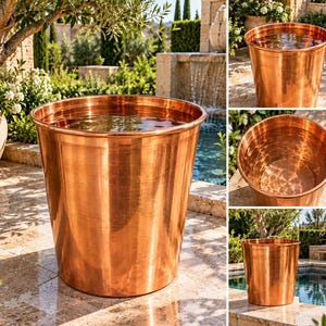 May include: A large, cylindrical copper basin with a polished, reflective metallic finish. The vessel features a wide, open top and a smooth, tapered body. The interior is deep and circular, showing the warm, reddish-brown hue of the copper material.