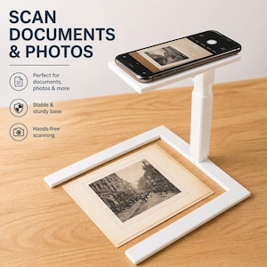 May include: A white document and photo scanner with a smartphone on top, positioned over a vintage photograph. The scanner has a stable base and is designed for hands-free scanning. Text on the image reads "SCAN DOCUMENTS & PHOTOS".