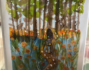 Tarjeta con imagen de una mujer en un campo de flores y árboles, con sobre incluido.