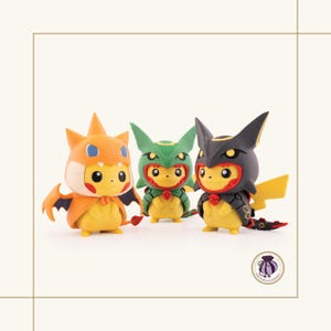 May include: Three Pikachu figurines dressed as other characters. The figurines are yellow with orange, green, and black accents. Each figure has a unique costume and pose, with a small red bow tie.