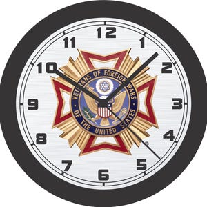 Può includere: Orologio da parete rotondo con una cornice nera e un quadrante bianco. L'orologio presenta lancette e numeri neri e un emblema centrale con la scritta "VETERANS OF FOREIGN WARS OF THE UNITED STATES".