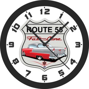 May include: Round wall clock with a black bezel and white face. The clock features a Route 55 graphic with a red and silver classic car. The clock hands are black, and the numbers are in a black, bold font.
