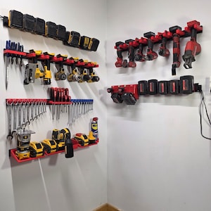 May include: A wall-mounted tool organization system featuring red plastic racks and brackets. The setup includes rows for power tool batteries, cordless drills, impact drivers, wrenches, screwdrivers, and various handheld power tools in yellow and red.