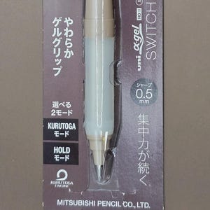 Peut inclure: Un nouveau crayon mécanique Uni Kuru Toga Switch non ouvert dans son emballage d'origine. Le crayon est beige et blanc avec un clip argenté. L'emballage comprend du texte japonais et les mots "Limited Edition". Le crayon a une mine de 0,5 mm.