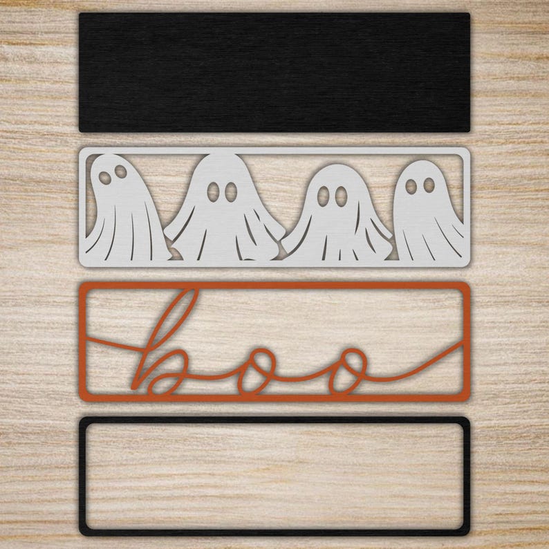 May include: Four rectangular signs arranged vertically. The top is solid black. The second is a silver-toned frame containing four ghost silhouettes. The third is an orange-toned frame with the word boo in cursive script. The bottom is a black frame.