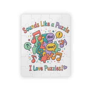 Op de afbeelding: Een rechthoekige legpuzzel met de tekst Sounds Like a Puzzle en I Love Puzzles. Het ontwerp bevat kleurrijke puzzelstukjes, muzieknoten en tekstballonnen met de woorden Aha! en Hmm? samen met een vraagteken op een witte achtergrond.
