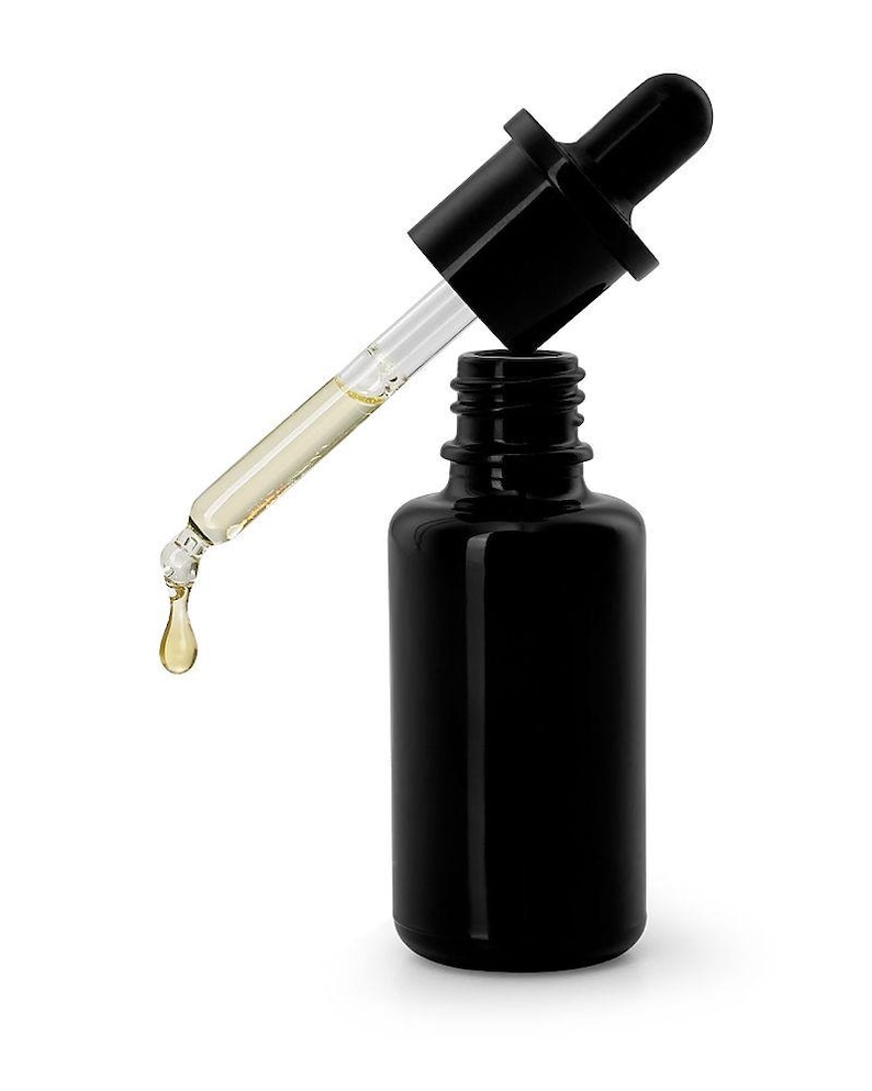 May include: A black glass bottle with a dropper dispensing a golden liquid. The dropper is black with a clear glass tube. A single drop of the liquid is falling from the dropper.