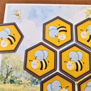 May include: A collection of hexagonal stickers featuring a cartoon bee with yellow and black stripes and light blue wings. The stickers are arranged on a background illustration of a blue sky, white clouds, and green trees, with one bee flying.
