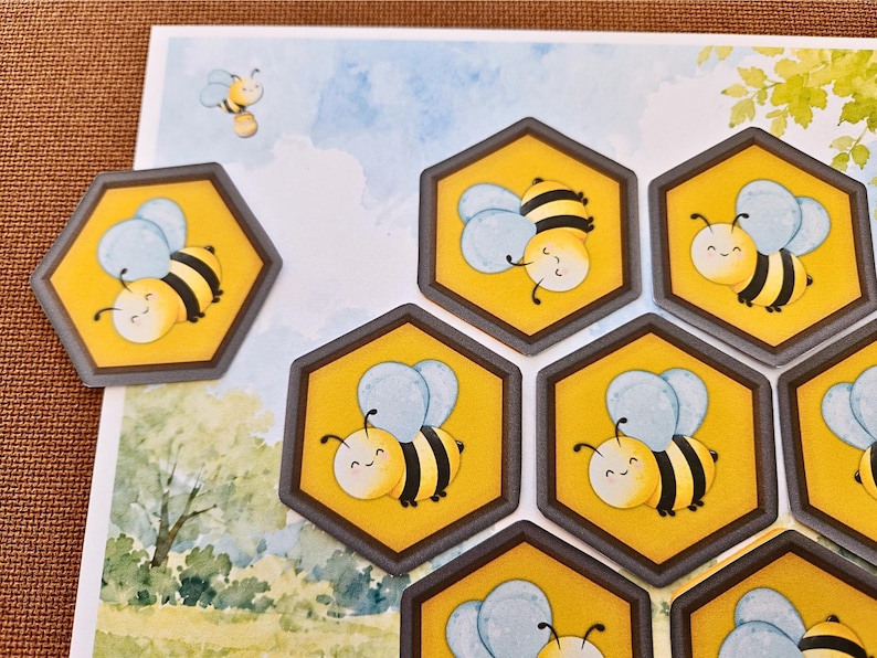 May include: A collection of hexagonal stickers featuring a cartoon bee with yellow and black stripes and light blue wings. The stickers are arranged on a background illustration of a blue sky, white clouds, and green trees, with one bee flying.