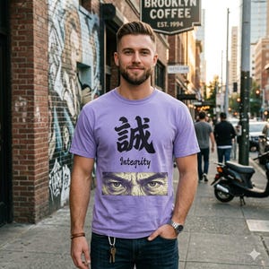 以下が含まれることがあります： 薄紫色の半袖Tシャツ。胸元には「誠」という黒い日本語の漢字、その下に英語で「Integrity」という文字、さらにその下に力強く詳細に描かれた人間の目のペアが長方形のグラフィックとしてプリントされています。