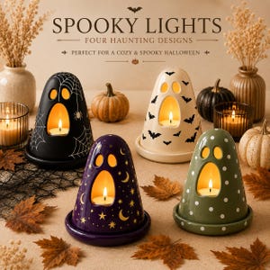 May include: Four ghost-shaped ceramic candle holders in black with spiderwebs, cream with bats, purple with stars and moons, and olive green with white polka dots. Each features a cutout face and holds a lit tea light candle on a matching base.