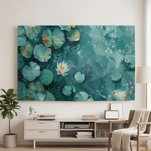 Op de afbeelding: Een canvas print met een serene waterpartij met waterlelies en een witte waterlelie. Het kunstwerk toont tinten groen en blauwgroen, met waterdruppels en lichtreflecties. Het thema is natuur en rust.