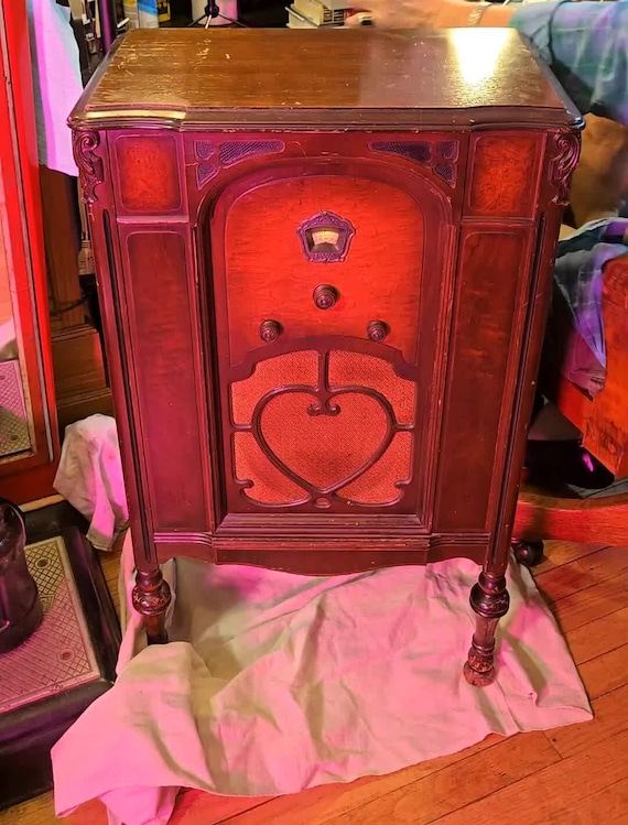 A genuine 1932 Fada console radio gutted and reborn as a Bluetooth speaker — glowing tubes, real wood cabinet, and 90-year-old industrial design doing modern audio duty.