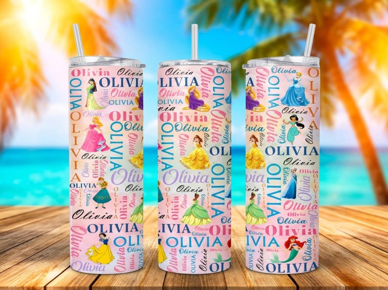 May include: Three pink insulated tumblers with princess illustrations and the name "Olivia" repeated in a pattern. Each tumbler has a white straw. The background shows a beach scene with palm trees.