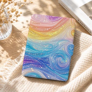 May include: A rectangular e-reader case featuring a vibrant, swirling abstract pattern that transitions from warm orange and yellow tones at the top to cool blue and purple hues at the bottom, accented with a sparkling, glitter-like texture.