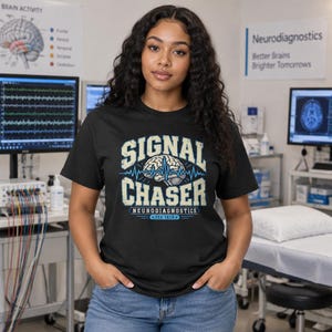 Puede incluir: Una camiseta negra de manga corta con un estampado gráfico que incluye el texto SIGNAL CHASER, NEURODIAGNOSTICS y EEG TECH. El diseño presenta una ilustración central de un cerebro humano con una línea de ECG azul cruzada.