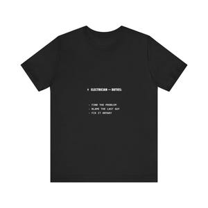 May include: A black short-sleeve t-shirt featuring white text that reads: ELECTRICIAN — DUTIES: - FIND THE PROBLEM - BLAME THE LAST GUY - FIX IT ANYWAY. The shirt has a crew neckline and a standard fit, displaying the printed list on the chest.