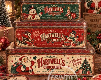 May include: Three rectangular metal tins stacked vertically. The top tin is green with a snowman and text reading Hartwell's Chocolate. The middle tin is red with a reindeer and snowman. The bottom tin is cream with Santa Claus and text.
