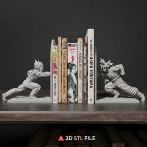 May include: Gray resin bookends featuring Dragon Ball Z characters, supporting a collection of books. The bookends depict Goku and Vegeta in dynamic poses. The books include titles like "Manga Art Theory" and "The World of Akira Toriyama."