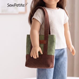 May include: A doll wearing a white t-shirt and blue jeans, carrying a two-tone tote bag. The tote bag is green and brown with a brown handle. The text "Made" is visible on the bag. The brand name "SewPetite" is in the upper left corner.