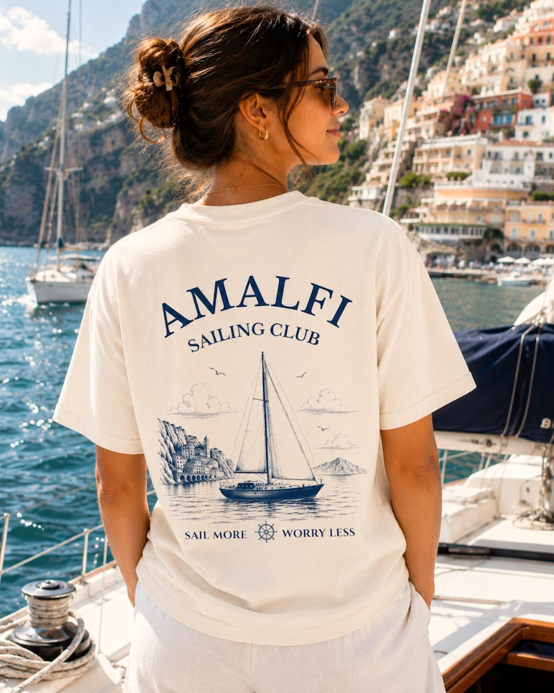 Woman wearing Amalfi Sailing Club shirt with large back design, inspired by Amalfi Coast vacations, sailing trips, and Mediterranean coastal style.