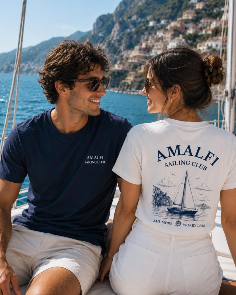 Couple matching shirts with Amalfi sailing club design on a yacht.