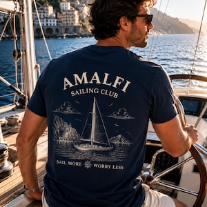 Man wearing Navy Amalfi Sailing Club shirt with large back print on a sailboat, perfect for yacht weekends, sailing trips, and boat lovers.