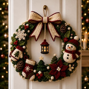 May include: A crocheted Christmas wreath featuring a large cream and maroon bow at the top, a central hanging lantern, a snowman, a mitten, a stocking, pinecones, poinsettia flowers, small pine trees, and white snowflakes on a green base.