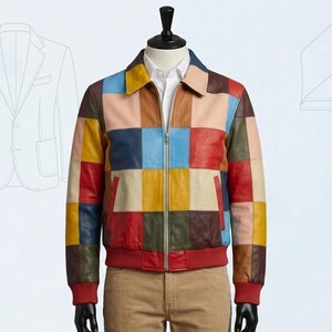 May include: A colorful patchwork leather jacket with a zip-up front, red cuffs, and a red waistband. The jacket features a variety of square-shaped color blocks in shades of red, blue, yellow, and pink. The jacket is displayed on a mannequin.