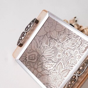 May include: A wooden serving tray with a silver frame and floral design. The tray has two ornate metal handles and a cord with a plug.